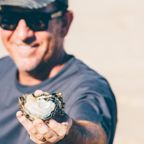Man offering an oyster in shell